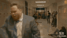 a group of people are fighting in a hallway in a school building .