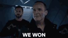 a man is standing in front of a group of men with the words `` we won '' written on his face .