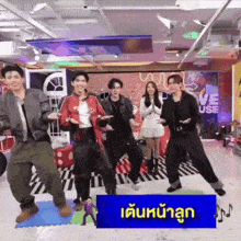 a group of people are dancing in a room with a sign that says ' love use ' on it