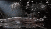 a person is laying on their back in a dark room with their arms outstretched
