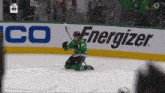 a hockey player is kneeling on the ice in front of an energizer ad