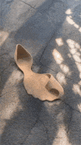 a sculpture of a rabbit is laying on a concrete surface