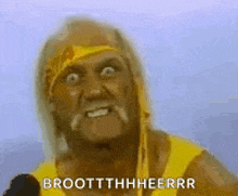 hulk hogan is wearing a yellow shirt and talking into a microphone while making a funny face .