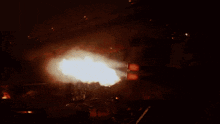 a huge fireball is being fired from a machine in a dark room
