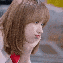 a close up of a woman making a funny face with her hand on her chin