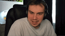 a man wearing headphones and a white shirt is sitting in a chair