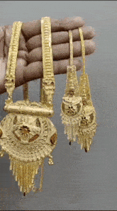 a person is holding a necklace and earring set in their hand .