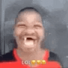 a man is making a funny face with his mouth open and a red shirt on .
