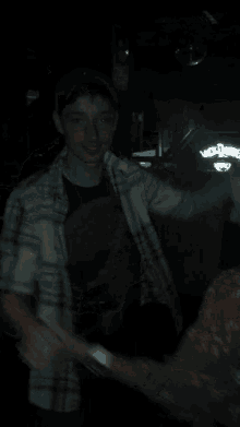 a man and woman dancing in front of a jack daniels sign