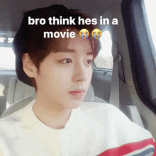 a young man in a car with the words bro think hes in a movie above him