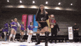 a woman in a wrestling ring is holding a belt that says a7