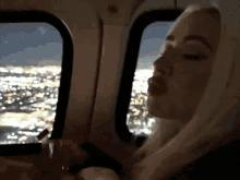 a woman blowing a kiss while looking out of a window