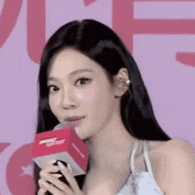 a woman is holding a microphone in her hand and smiling .