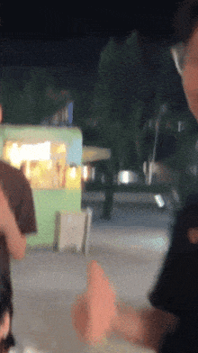 a blurry picture of a man giving a thumbs up in front of a food truck