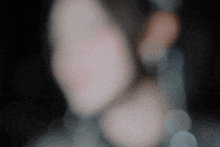 a blurred image of a person 's face with a dark background