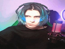 a man with blue hair is wearing headphones