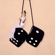 a woman in white tights is sitting on a pair of black dice