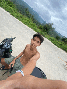 a shirtless young man is sitting on a motorcycle with a bracelet that says ' i love you ' on it