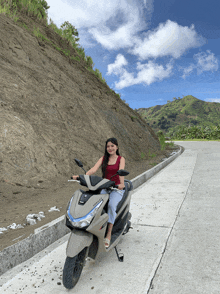 a woman riding a honda scooter on a road