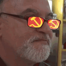 a man with a beard is wearing sunglasses with a hammer and sickle on the lenses