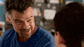 a man with a beard is talking to another man .