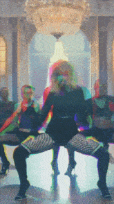 a woman is dancing in front of a chandelier in a room