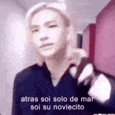 a blurry picture of a person with the words atras soi solo de mar soi su noviecito written on it .