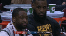 two men sitting in front of a gatorade container