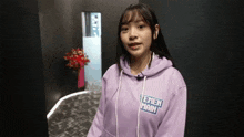 a girl wearing a purple hoodie with the word main on the front