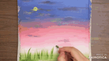 a person is painting a sunset with the words made in animotica below it
