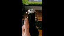 a person is opening a bottle of beer with a bottle opener .