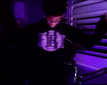 a man is standing in front of a microphone wearing a fbi hoodie .