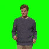 a man in a blue sweater holds his hands up in the air