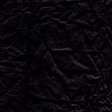 a crumpled piece of black paper with a cross in the middle