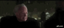 a person is holding a purple light saber in the dark .