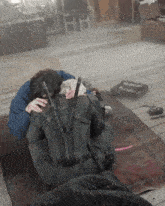 a man in a military uniform is hugging another man in a room