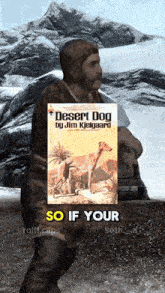 a man carrying a book titled desert dog by jim kielgaard
