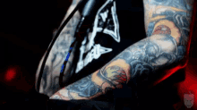 a man with a lot of tattoos on his arms and chest