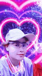 a person wearing glasses and a hat with a pink heart in the background