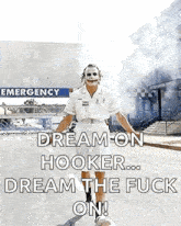 a man dressed as the joker is standing in front of an emergency room with smoke coming out of it .