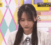a woman with long hair and a ponytail looks down