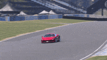 a red sports car is going around a curve on a track