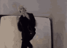 a man in a suit is standing on a mattress