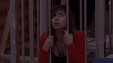 a woman with red hair is behind a wooden fence and looking up .