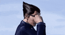 a man wearing sunglasses is covering his face with his hands .