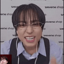 a young man wearing glasses and earphones is smiling .