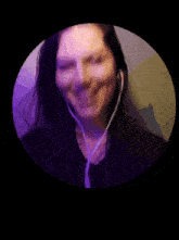 a woman wearing headphones is smiling and looking at the camera
