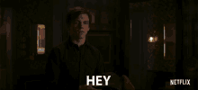a man in a dark room with the words hey netflix on the bottom