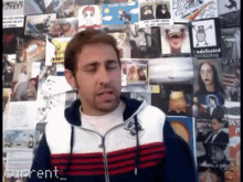a man is standing in front of a wall of pictures and the word current is visible