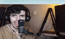 a man wearing headphones is talking into a microphone .